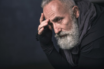 Portrait of serious bearded senior holding beads. Copy space. Abstraction concept