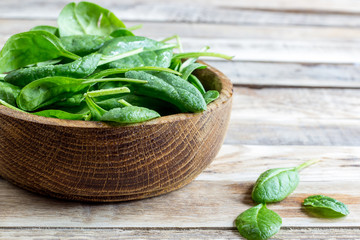 Fresh baby spinach in a wooden bowl