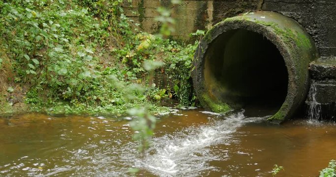 Build cement concrete pipe drainage canals drain the fluid flow. Cloudy day.