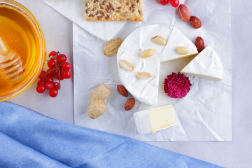 Cheese on white background, camembert, a glass of milk, Christmas cheese with honey, white background, blue napkin, pop art, red berries, Mexican cuisine, Indian cuisine, French breakfast