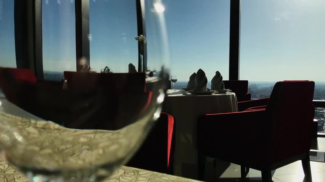 View Of The City Reflected In The Glass Of Wine. Footage. City view from the restaurant. Restaurant in a skyscraper overlooking the city, a glass in the foreground