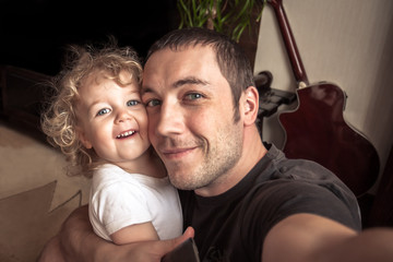 Cheerful father and daughter making family selfie 