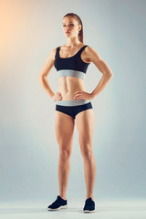 Fototapeta na wymiar Active lifestyle. Low angle view on a confident young woman posing with her hands on the hips while standing on feet shoulder width apart.