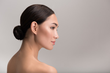 Natural female beauty concept. Side view profile of gorgeous exotic young naked woman is looking...