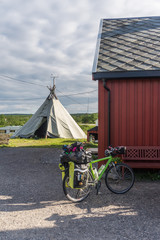 Tourist bicycle on the background of the traditional house of Sami, Finnmark, Norway