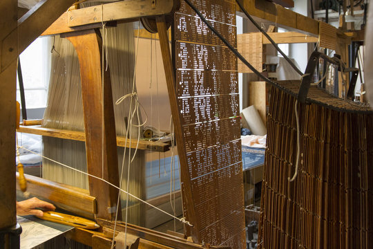 alter teilmaschineller Jacquard-Webstuhl aus Holz mit Lochkartensteuerung und eingelegten F&auml;den