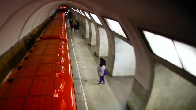 A red electric train carriage with an open sliding mechanical door at a train station platform. Footage