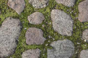 Fragment of the old road paved granite stones