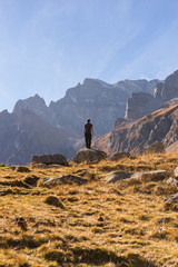 Young adult man hiker contemplate nature on mountain in sunny autumn day on Alps in Italy outdoor.