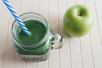 Green smoothie with apple on the wooden background