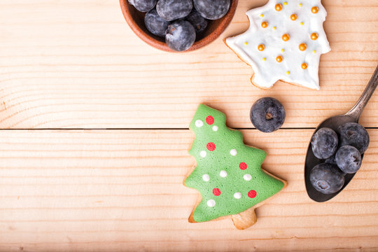 Ginger cookies with green icing fri tree on a light wood Christmas and New Year's background. Top view, copy space.