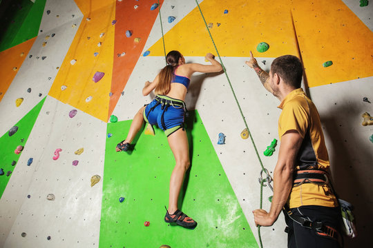 Young woman with coach in climbing gym