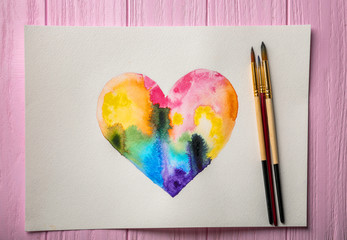 Naklejka premium Watercolor painting of rainbow heart on wooden background