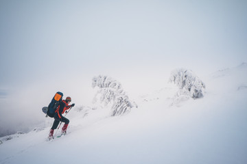 Extreme hiking with backpack in winter mountain landscape