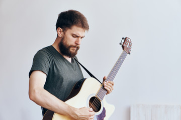 Man with a beard on a white isolated background playing a guitar, musical instruments