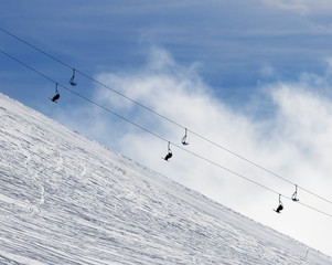 Fototapeta na wymiar Snowy off-piste ski slope and chair-lift in fog