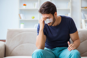 Young man recovering healing at home after plastic surgery nose 