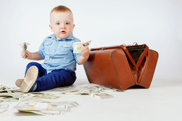 The child puts money. The boy considers dollars. Child with money.