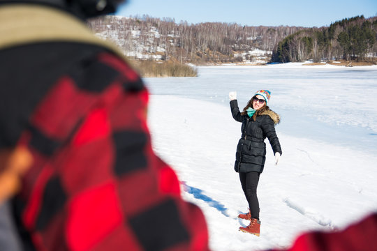 Couple Having A Snowball Fight On A Sunny Day