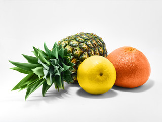 Isolated fruit photo Whole ripe pineapple, orange and a large juicy grapefruit are lying on a white background Close-up fruit photo