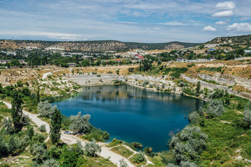 Fototapeta na wymiar Flooded quarry in Crimea. Blue pond on the place of former whiter limestone mine