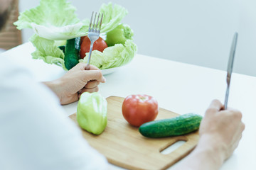 Man at the table on a white isolated background, vegetables, vegetarianism, diet