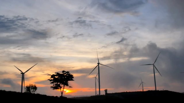 4K beautiful wind turbine in twilight sundown. Concept of renewable energy production in farm cornfield rural