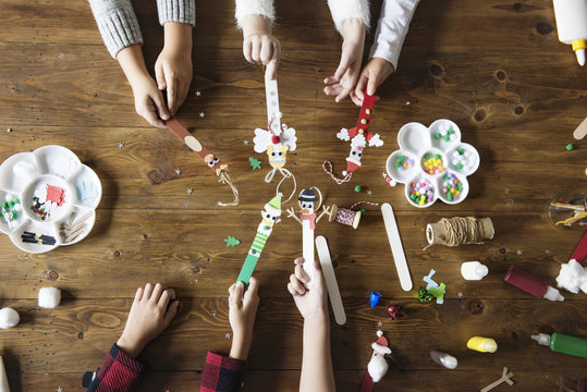 Little kids holding Christmas character decorated popsicle sticks