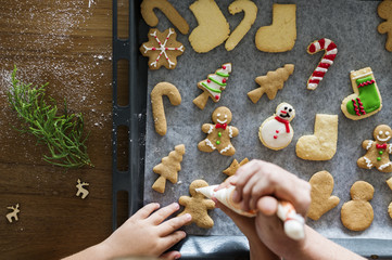 Gingerbread cookies getting decorated for Christmas - obrazy, fototapety, plakaty
