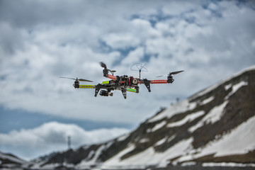 Naklejka na ściany i meble Drone in the snow mountains carbon quadrocopter