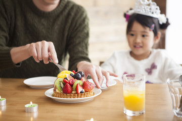 Dad and mommy are celebrating her daughter 's birthday.