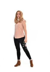 full length portrait of a girl wearing pink shirt and black floral pants. standing pose, isolated on white background.