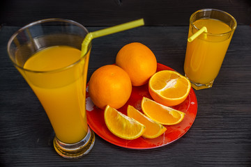oranges and orange juice on a wooden dark background