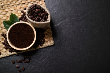 Top view mockup coffee beans and powder coffee in the bowl on black stone. Top view with copy space.