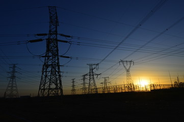 The silhouette of the evening electricity transmission pylon