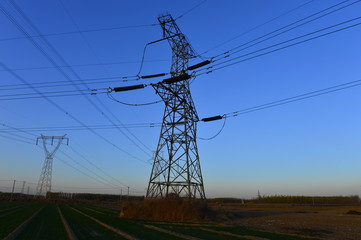 The silhouette of the evening electricity transmission pylon