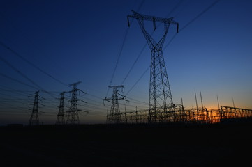 The silhouette of the evening electricity transmission pylon