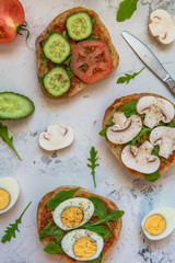 Ciabatta for breakfast. Sandwiches with arugula, egg, mushrooms, cucumbers and tomatoes