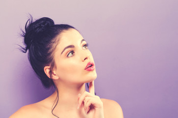 Young woman looking upward on a solid background