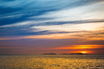 Sky and sunset behind the mountains at sea.