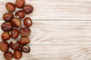 chestnut on white wooden background with copy space for your text. Top view. Flat lay.