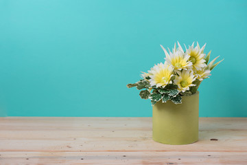 yellow flower on wooden table with green background