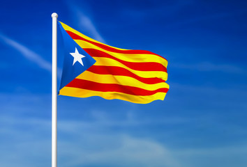 Waving flag of Catalonia on the blue sky background