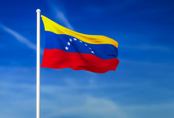 Waving flag of Venezuela on the blue sky background