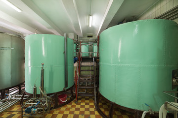 Large metallic cisterns of green color. Manufacture of alcoholic beverages.