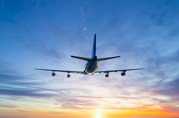 passenger airliner flying over the sea against backdrop of the setting sun