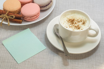 Cake macaroon, coffee Cup and space for text on a sheet of paperб close up