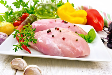Chicken breast raw in plate with vegetables on board