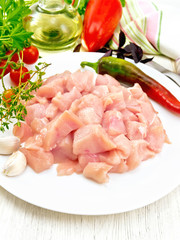 Chicken breast raw sliced in plate with vegetables on light boar