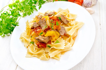 Farfalle with turkey and vegetables in sauce on light board